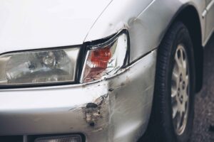 a white color car with broken headlight