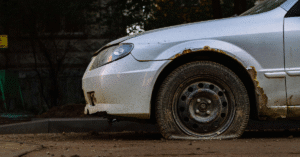 white car with flat tire